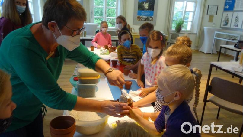 Edith Niebler füllt die kleinen Tontöpfe der Kinder mit Brotteig. Bild: hka