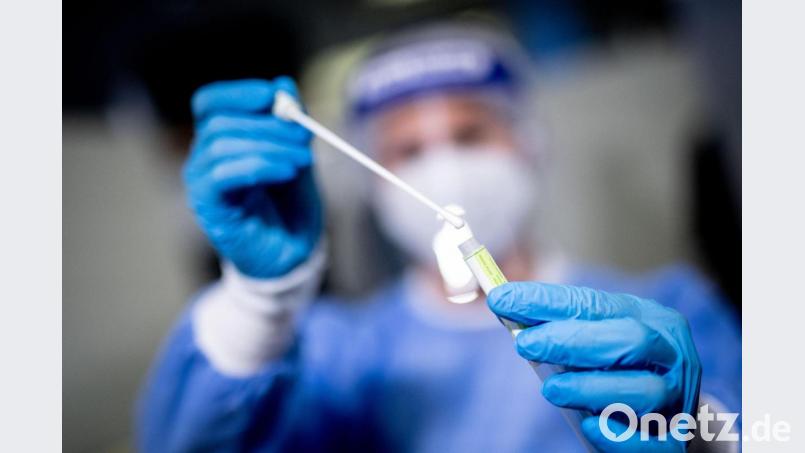 Eine Frau hält am Flughafen München in einem Covid-19 Testcenter die Probe von einem Rachenabstrich in den Händen. Politiker aus unterschiedlichen Parteien diskutieren, ob Coronatests weiterhin kostenlos für Alle sein sollen. Foto: Matthias Balk/dpa Bild: Matthias Balk