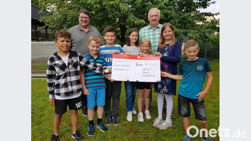Statt Gegengeschenke zur Kommunion spendeten sieben Kinder und ihre Familie Geld für die Kinderkrebshilfe in der Region Oberpfalz Nord. Vorsitzender Herbert Putzer (rechts) und Pfarrer Udo Klösel (links) danken dafür. Bild: gi