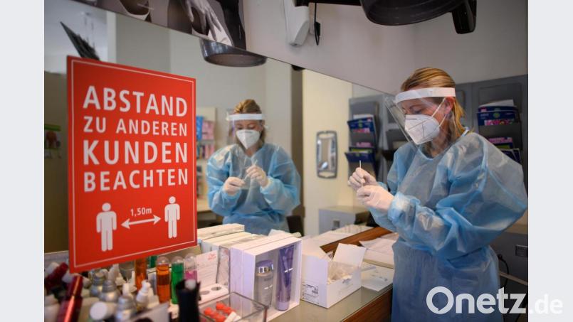 Das Friseurhandwerk war vom ersten Lockdown besonders betroffen: Eine Mitarbeiterin im Friseurstudio wertet einen Antigen-Schnelltest aus. Bild: Robert Michael/dpa
