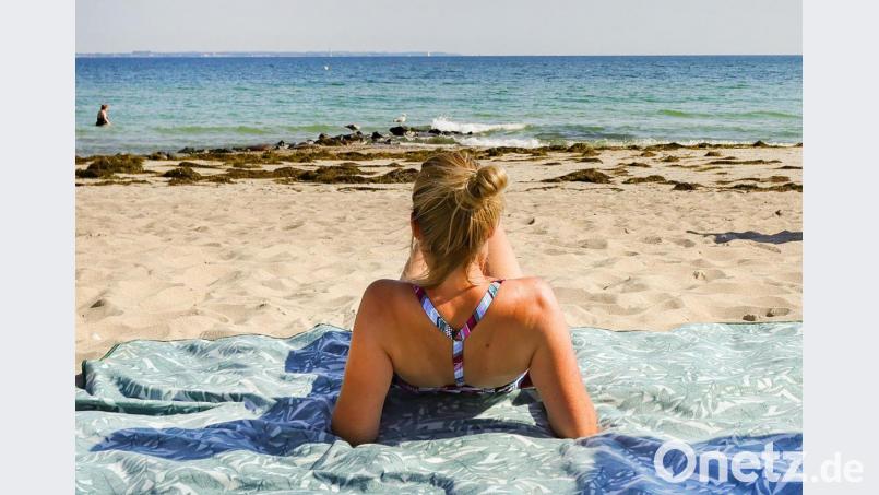 Eine Urlauberin genießt das sommerliche Wetter am Ostseeufer in Timmendorfer Strand. Symbolbild: Ulrich Perrey/dpa