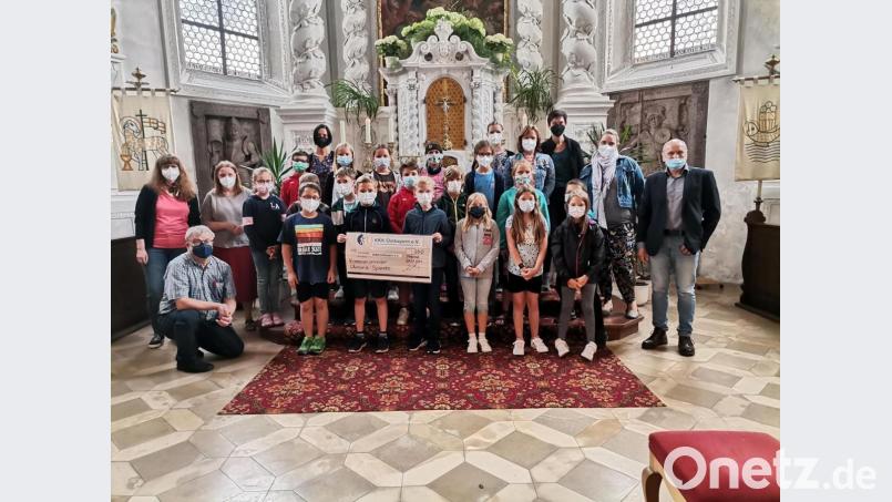 Josef Trottmann (rechts) konnte in der Pfreimder Pfarrkirche von den Kommunionkindern eine Spende in Höhe von 500 Euro entgegennehmen. Bild: hir