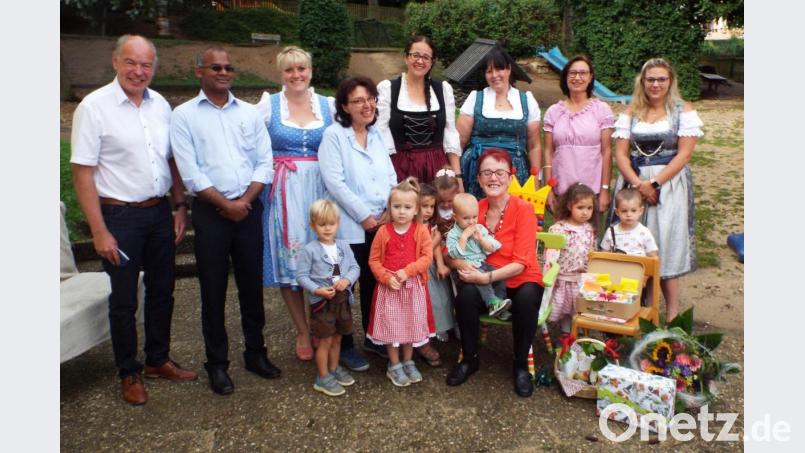 Kinderpflegerin Maria Lautenschlager (sitzend inmitten ihrer Kinder) wird verabschiedet von (von links) Bürgermeister Strehl, P. Sainat Thomas Arokiasamy und Christine Schmeiler sowie Leiterin Nadine Rall (Dritte von rechts). Bild: e