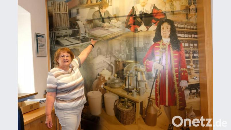 Museumsleiterin Rosemarie Zithier vor der Bildcollage im Eingang des Museums mit Doktor Eisenbarth. Bild: Hirsch