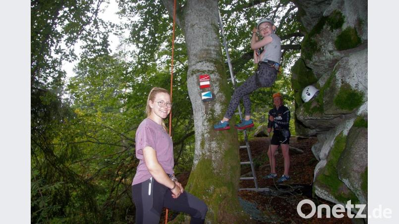 Die Geschwister Constanze (links) und Philipp Gibhardt (rechts) aus Falkenberg betreuten die Kletterbuche, die mit Seil, Haken und mit einem Schutzhelm ausgestattet, erkundet werden durfte . Bild: wro