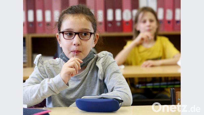 Schülerinnen machen den &quot;Lolli-Test&quot;. Bayern will zum neuen Schuljahr PCR-Pooltests an Grund- und Förderschulen einführen: Das war ein Thema bei einer Tagung der Oberpfälzer Landräte in Bodenwöhr. Symbolbild: Roland Weihrauch/dpa