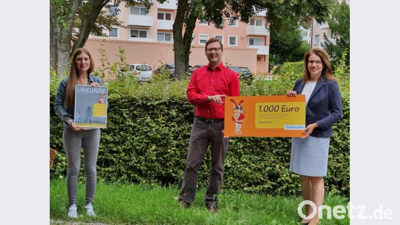Wolfgang Dumm (Mitte) überreichte das Lesezeichen an Leonie Flachsmann (links) und Zweite Bürgermeisterin Martina Englhardt-Kopf (rechts). Bild: Annemarie Pösl/exb