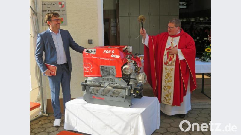Mit viel Weihwasser spendet Pfarrer Sven Grillmeier (rechts) der neuen Tragkraftspritze der Mockersdorfer Feuerwehr den kirchlichen Segen. Bürgermeister Wolfgang Haberberger (links) übernimmt im Gottesdienst die Aufgabe des Lektors. Bild: ow