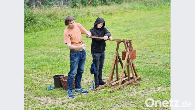 Jürgen Weigert (links) bereitet das Trébuchet sorgfältig für den Schuss vor. Bild: cog