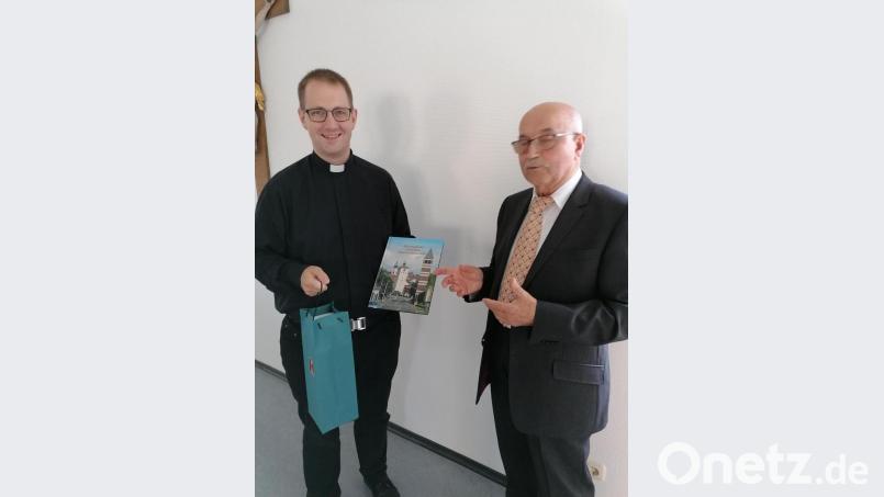 Vorsitzender Elmar Pilz (rechts) überreichte dem scheidenden Präses Daniel Fenk Geschenke und wünschte damit gute Erinnerungen an die Kaplanszeit. Bild: kod