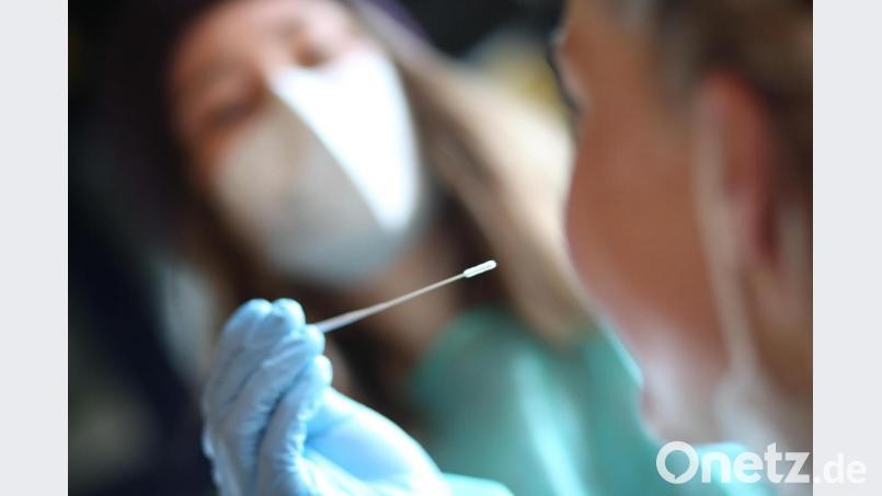 Eine Mitarbeiterin nimmt in einem Testzentrum einen Speicheltest von einem Besucher ab. Symbolbild: Matthias Bein