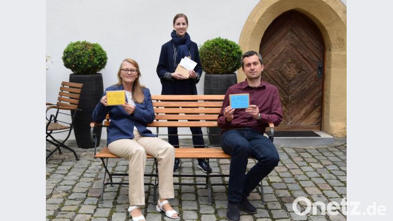 Sigrid Merkl, Julia Riss und Michael Herzog mit den Sprichwort-Karten im Hof des Stadtmuseums Amberg. Bild: Stadtmuseum Amberg/Dagmar Lehner/exb