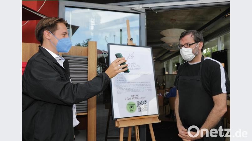 Wenn Ferdinand Winter (links) als Gast ins Café Kult in Amberg möchte, muss er seine 3G-Tauglichkeit beweisen. Inhaber Norbert Stöckl (rechts) und sein Team kontrollieren das. Bild: Wolfgang Steinbacher