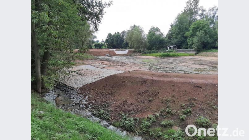 Die drei verpachteten gemeindeeigenen Weiher erfüllen zukünftig die Funktion eines Regenrückhaltebeckens, die gepflasterten Flächen auf den Dämmen sind als Überläufe konzipiert. Die Teiche wurden wie der Bachlauf links im Bild in den letzten Wochen mit Baggern ausgeputzt und vertieft und werden wieder bis zu ihrem üblichen Niveau gefüllt. Bild: ise