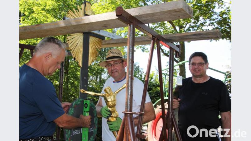 Mit vereinten Kräften: Klaus Keim, Bernd Schwamberger und Alois Sladky (von links) beim Aufstellen des Feldkreuzes am Gaisbühl. Bild: kro