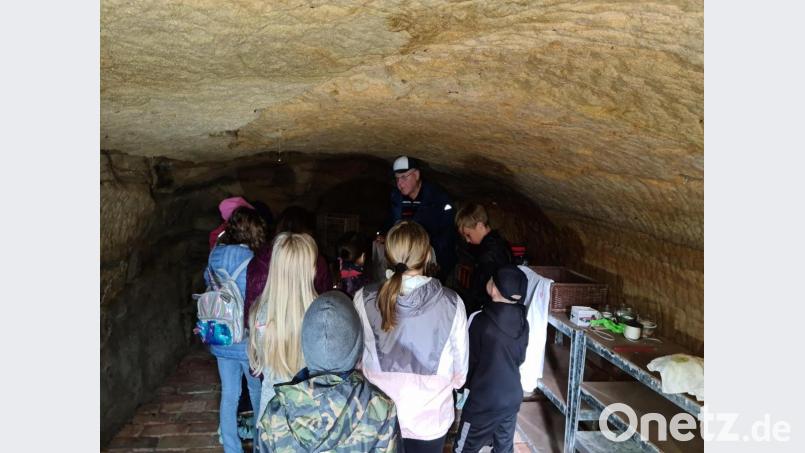 Altbürgermeister Helmut Wächter erklärt den Kindern die historischen Felsenkeller unter dem Annaberg. Bild: sne