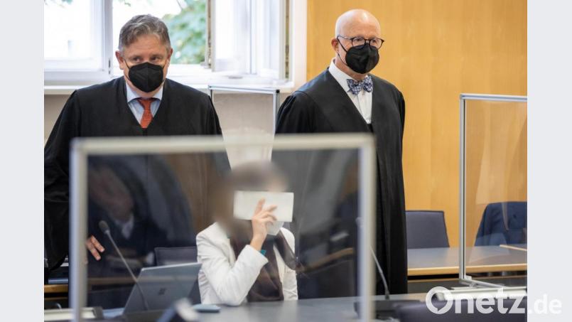 Die angeklagte Frau hält sich neben ihren Anwälten Andreas Kaiser (l) und Michael Haizmann im Landgericht Regensburg ein Blatt vors Gesicht. Archivbild: Daniel Karmann