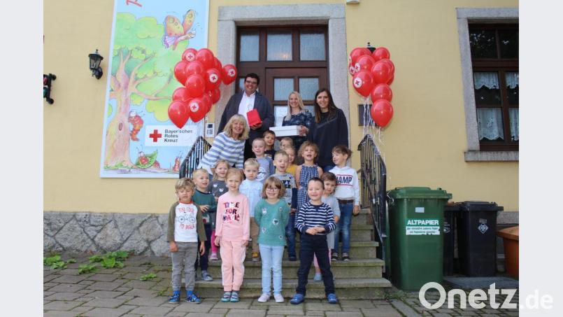 Einrichtungsleiterin Alice Hübsch (hinten rechts) und BRK-Kreisgeschäftsführer Holger Schedl (hinten links) mit den Kindern und Mitarbeiterinnen im Kindergarten Piccolino an ihrem ersten Tag unter der Trägerschaft des BRK. Bild: Sven Lehner/exb