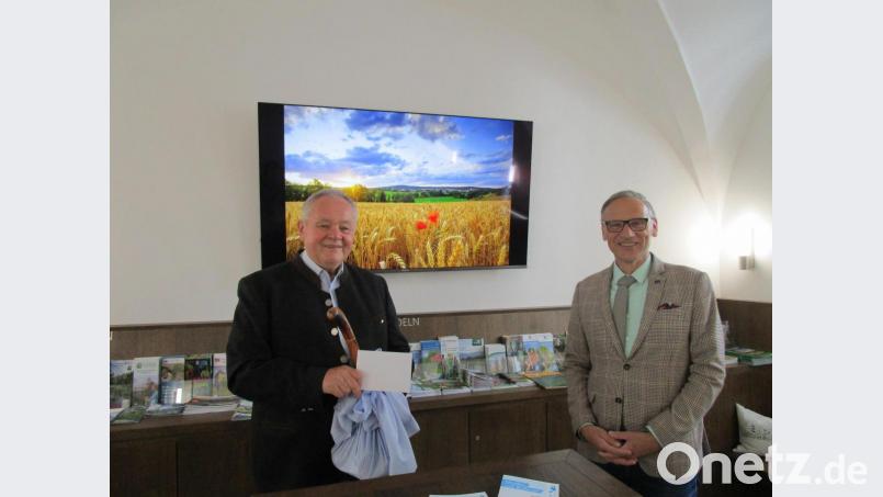 Bürgermeister Bernd Sommer (rechts) bedankte sich bei Gerhard Paintner für das dessen Engagement und überreichte neben einem Pilgerstab mit deftiger Brotzeit einen Wirtshaus-Gutschein. Bild: Stadt Waldsassen/exb