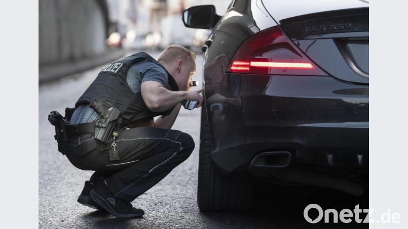 Mit einer Taschenlampe kontrolliert ein Beamter ein aufgemotztes Auto auf mögliche Verkehrsbeeinträchtigungen. Das passiert auch in Schwandorf immer wieder. Symbolbild: Boris Roessler/dpa