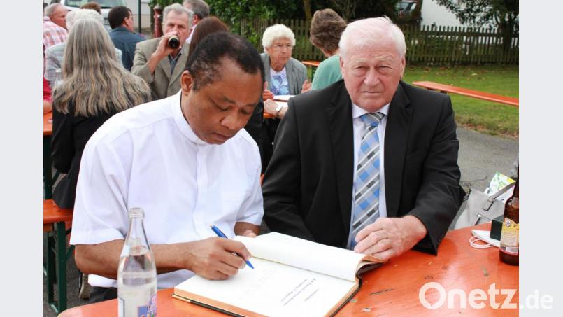 Während der Feier trug sich der scheidende Pfarrer Cyprian Anyanwu ins Goldene Buch der Gemeinde Guteneck ein. Bild: Verwaltungsgemeinschaft Nabburg / exb