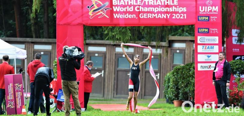 Eine junge Ägypterin läuft als Siegerin durchs Ziel: Die WM im Biathle und Triathle lockte knapp 300 Sportler aus 25 Ländern ins Weidener Schätzlerbad. Bild: Büttner