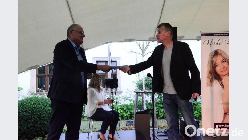 Schirmherr Lothar Höher überreicht Wolfgang Göldner einen Geldbetrag. Bild: Kunz