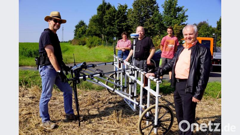 Mit einem Magnetometer suchte Dr. Markus Tarasconi (links) nach Spuren der Vergangenheit in der Erde. Bürgermeister Günter Kopp (rechts) und Hans Bäte (Mitte) ließen sich das Verfahren erklären. Auch die Grundstückseigentümer im Hintergrund sind gespannt auf das, was möglicherweise in ihrem Boden verborgen ist. Bild: bkr