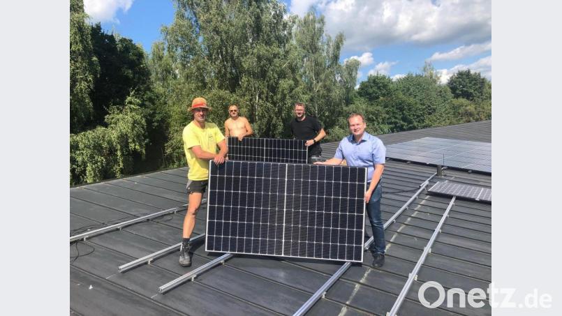 Das Team von EMK mit Chef Marco Kaußler (links vorne) installiert die Photovoltaik-Anlage auf der Kita Sankt Franziskus. Bürgermeister Christian Porsch (rechts) überzeugt sich von der fachgerechten Ausführung. Bild: ak