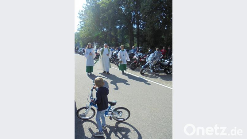 Beim Freiluftgottesdienst erhielten auch die &quot;kleinsten Fahrzeuge und Fahrer&quot; von Pfarrer Wilhelm Bauer (Mitte) den Segen. Bild: rfi