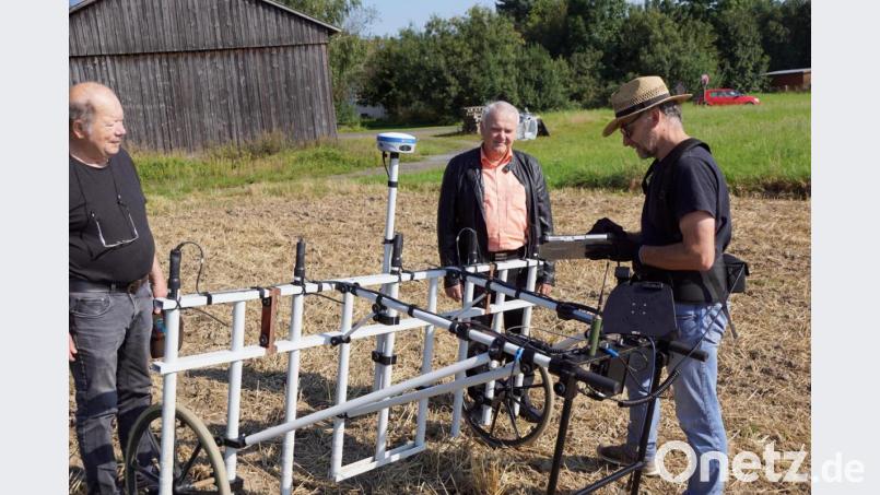 Ein seltsam anmutendes Gerät wurde am Montag über die erste Fläche von 8000 Quadratmeter fast zwei Stunden gezogen. Ein Magnetometer war es, mit dem Dr. Markus Tarasconi (rechts) nach Spuren der Vergangenheit in der Erde suchte. Bürgermeister Günter Kopp (Mitte) und Hans Bäte (links) ließen es sich erklären. Bild: bkr