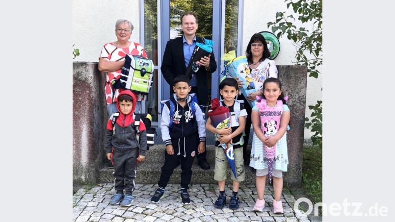 Dolores Longares-Bäumler, Bürgermeister Christian Porsch und Heidi Lauterbach (hinten von rechts) übergaben die ersten Schultaschen und -tüten an Mohammad, Chuder, Mohammad und Sabinas (vorne von links). Bild: hai