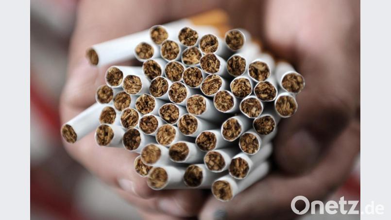 Ein Mitarbeiter des Zoll hält Zigaretten in seiner Hand. Symbolbild: Christian Charisius/dpa