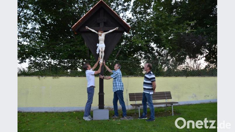 Beim Aufstellen des umfassend restaurierten Friedhofskreuzes auf dem Waldauer Friedhof dankte Kirchenpfleger Helmut Graf (rechts) den beiden tatkräftigen Helfern Franz Wiesent (links) und Erich Sauer (Mitte). Letzterer versuchte sich als "Künstler" und trug mit seiner Tochter Melanie die feinen Zeichnungen an der Christusfigur auf. Bild: dob