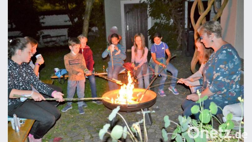Im Anschluss an die &quot;Taschenlampen-Kirchturmführung&quot; gab es Stockbrot und Würstchen am Lagerfeuer im Dekanatsgarten. Bild: hcz