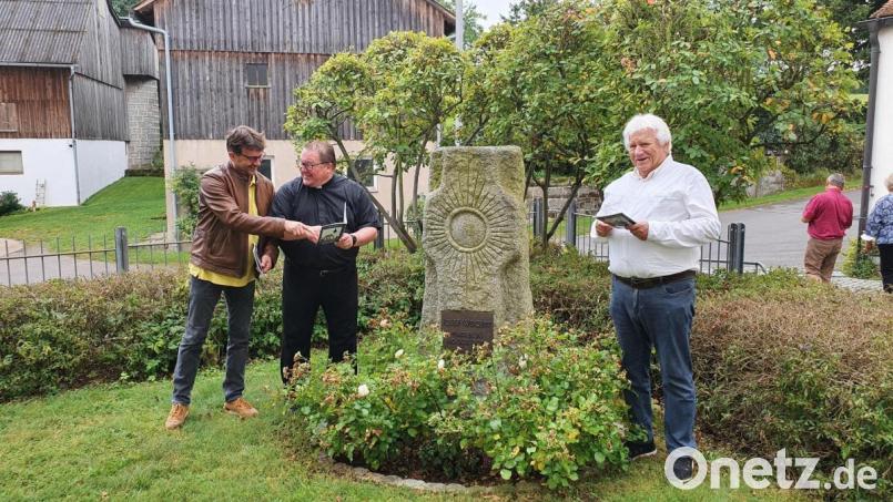 Am Gedenkstein für den Bauernpfarrer und geistlichen Rat Joseph Weigert verteilten am vergangenen Sonntag Bürgermeister Wolfgang Haberberger (links) und Pfarrer Sven Grillmeier (Mitte) anlässlich des 75. Todestags die ersten Exemplare der Gedenkschrift über den berühmten Mockersdorfer Pfarrer. Verfasst hatte die Broschüre der Heimatforscher Georg Miedel (rechts). Bild: ow