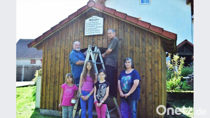 Auf der Leiter stehen (von links) Adolf Troglauer und der OGV-Vorsitzende Heinz Pickel, rechts daneben die Zweite Vorsitzende Gertraud Troglauer. Mit im Bild sind drei Schulkinder aus Altensee, die Nutzer des aufgehübschten Bushäuschens sind. Bild: no