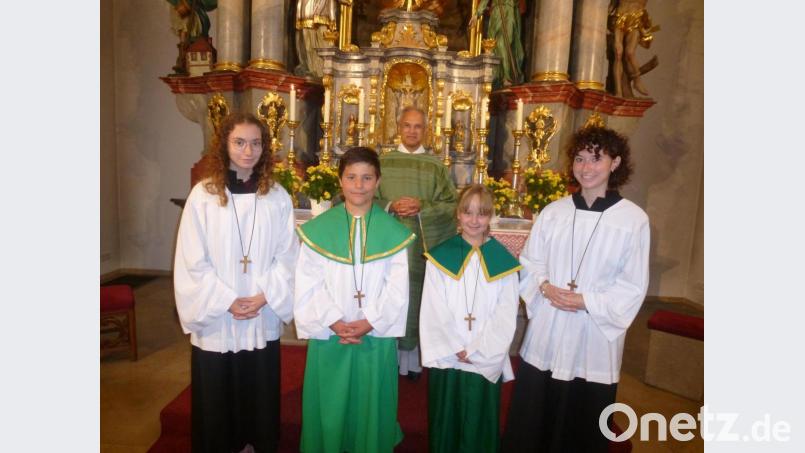 Pfarrer Varghese Puthenchira führt Johannes Lobenhofer und Julia Bauer in ihren Dienst als Ministranten ein. Mit dabei Carina und Verena Messer (von links). Bild: bk