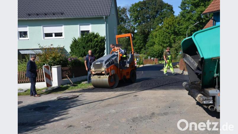 Teermaschine und Walze arbeiteten abwechslungsweise am Angerweg in Waldau, um den Straßenzug zu erneuern. Bürgermeister Andreas Wutzlhofer (links) und Außendienstleiter Karl Frey (Zweiter von links) schauten auch vorbei. Bild: doj