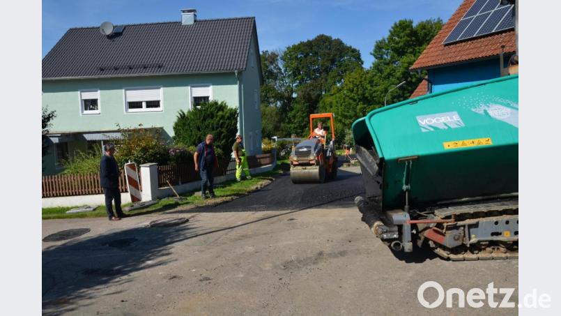 Teermaschine und Walze arbeiteten abwechslungsweise am Angerweg in Waldau, um den Straßenzug zu erneuern. Bürgermeister Andreas Wutzlhofer (links) und Außendienstleiter Karl Frey (Zweiter von links) schauten auch vorbei. Bild: doj