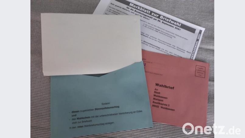 Der blaue Umschlag für den Stimmzettel ist deutlich zu klein. Er muss noch einmal gefaltet werden, damit er ins Kuvert passt. Bild: pz