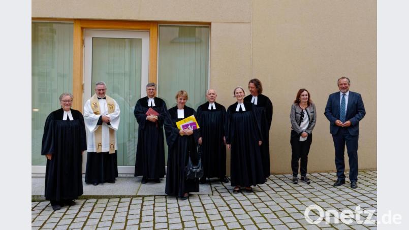 Die neue Pfarrerin Barbara Hofmann (Vierte von links) zeigt das Bild zusammen mit Pfarrerin Heidi Gentzwein, Stadtpfarrer Hannes Lorenz, Dekan Karlhermann Schötz, Pfarrer Norbert Schlinke , Pfarrerin Ruth Schlinke, Pfarrer Arne Langbein, Zweiter Bürgermeisterin Johanna Mertins und Bürgermeister Frank Zeitler (von links). Bild: Maria Linke/exb