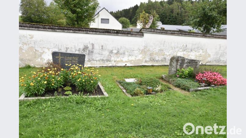 Blick auf einen Ausschnitt des Friedhofs in Götzendorf mit der sanierungsbedürftigen Mauer und den verrotteten Holzschindeln als Abschluss Bild: no