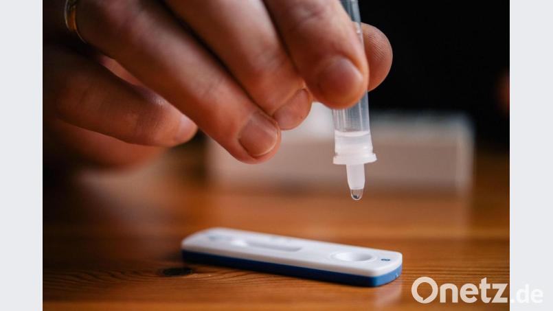 Ein Mann träufelt eine Lösung auf eine Testkassette für einen Schnelltest. Symbolbild: Zacharie Scheurer/dpa