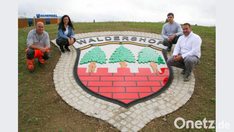 Vor einigen Wochen war hier noch eine blühende Margeriteninsel. Nun zieren vier Logos den Bereich. Das Waldershofer Stadtwappen präsentieren (von links) Bauhofleiter Markus Kremser, Bürgermeisterin Margit Bayer, Martin Giese (verantwortlich für die Ausführung der Arbeiten an den vier Logos) und Lohnunternehmer Klaus Bayer, der für die Erd- und Pflasterarbeiten verantwortlich zeichnet. Bild: fpoz