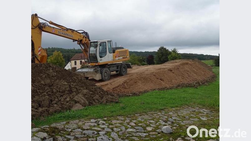 Sieht aus wie ein Übungsgelände für Mountainbiker, ist aber die Folge einer unliebsamen Überraschung: Gleich neben dem Rathaus in Wolfring (im Hintergrund) türmen sich riesige Sandberge, die über Jahrzehnte hinweg im Unterbau einer Gemeindeverbindungsstraße lagen Bild: Houschka