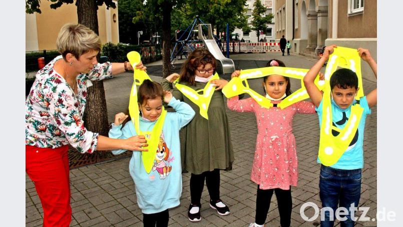 Alexandra Wildenauer hilft den Kindern beim Anziehen der Warndreiecke. Bild: R. Kreuzer