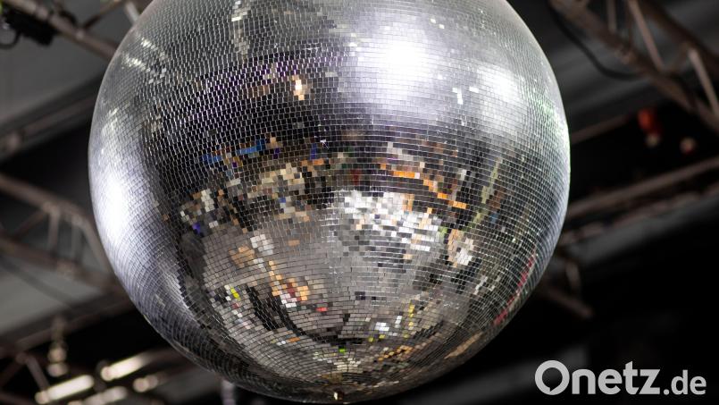 In einer großen Discokugel spiegelt sich die leere Tanzfläche einer geschlossenen Disco. Im Oktober wird sich das endlich ändern. Symbolbild: Jens Büttner/dpa
