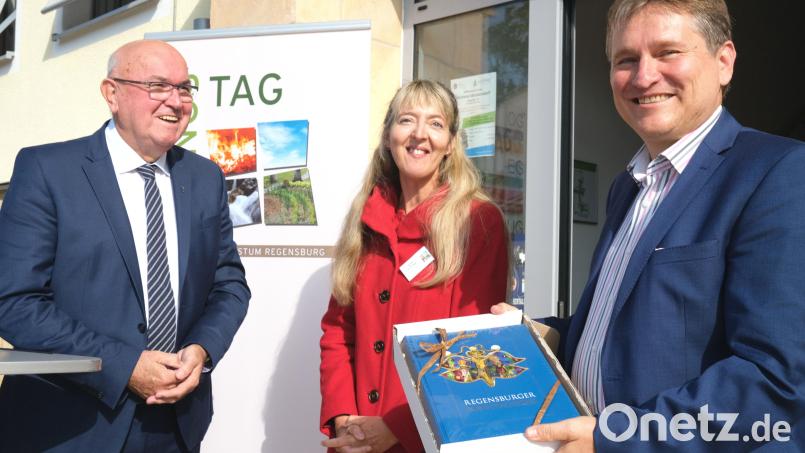 Dekan Hans Amann (links) und die Organisatorin des Schöpfungstages, Beate Eichinger (Mitte), überreichten Professor Dr. Manfred Miosga (rechts) eine Ausgabe der &quot;Regensburger Sonntagsbibel&quot;. Bild: Hirsch