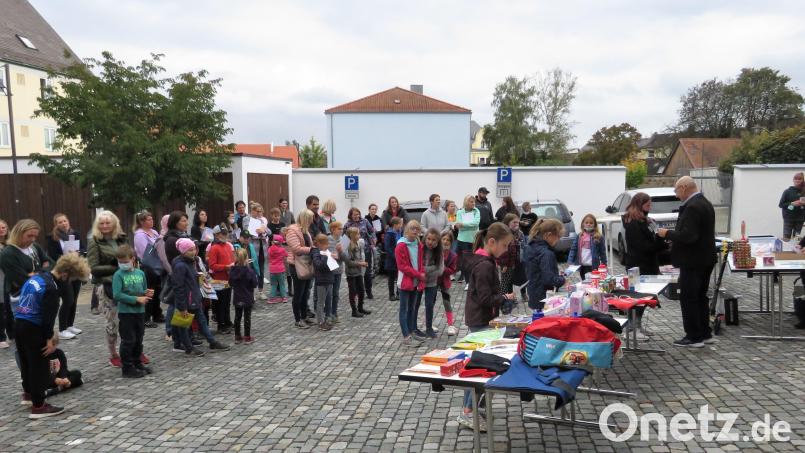 Nahezu der Großteil der Leseclubteilnehmer fanden sich meist in Begleitung der Eltern oder Verwandten zur Preisübergabe auf dem Parkplatz hinter dem Rathaus ein. Bild: ubb